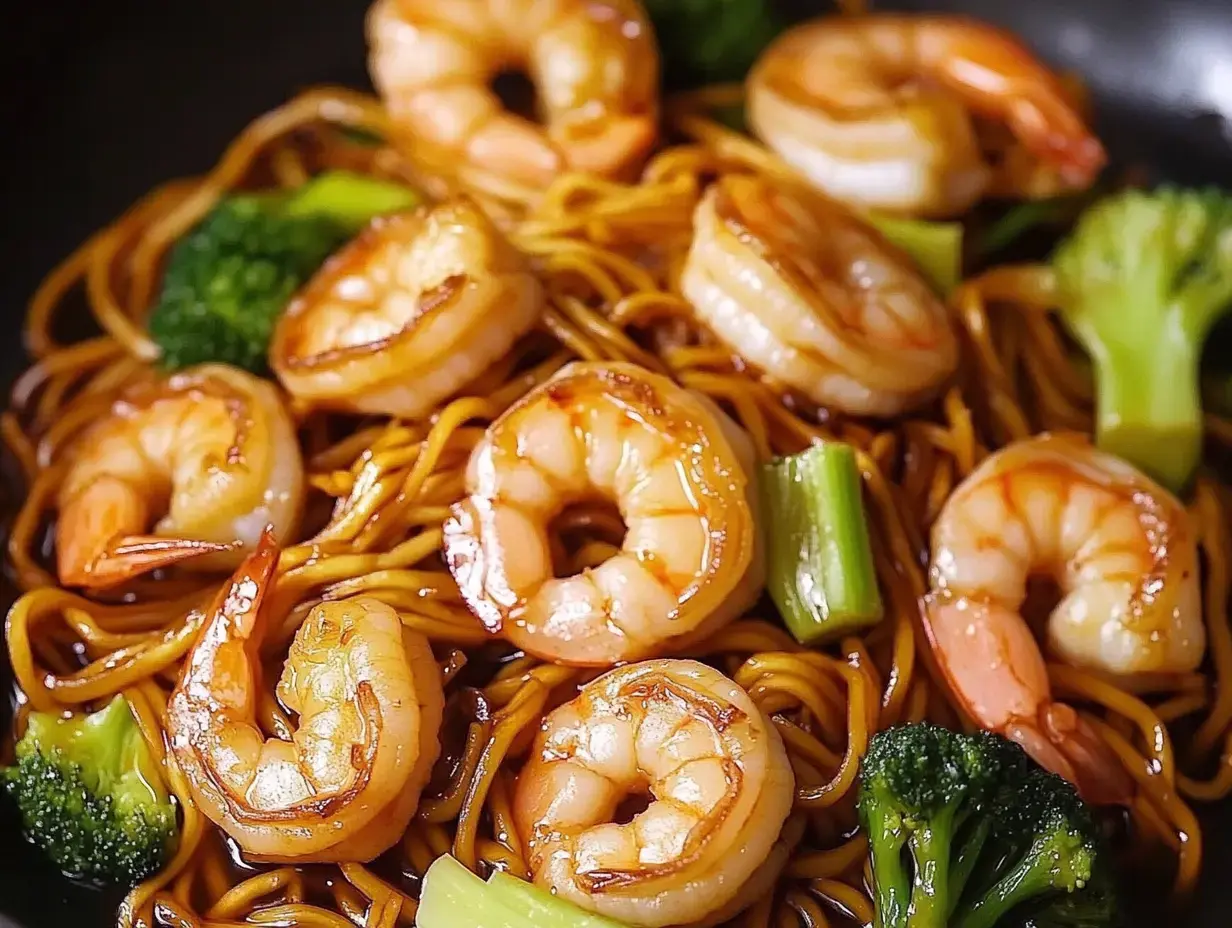 Fideos salteados, camarones por encima y brotes de brócoli, foto cercana.