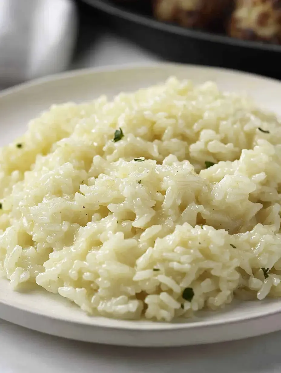 Arroz mantecoso y cremoso en un plato, adornado con hierbas.