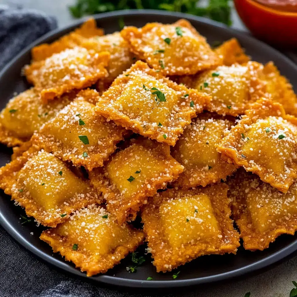 Un plato negro lleno de ravioles fritos dorados, espolvoreados con queso rallado y perejil fresco.
