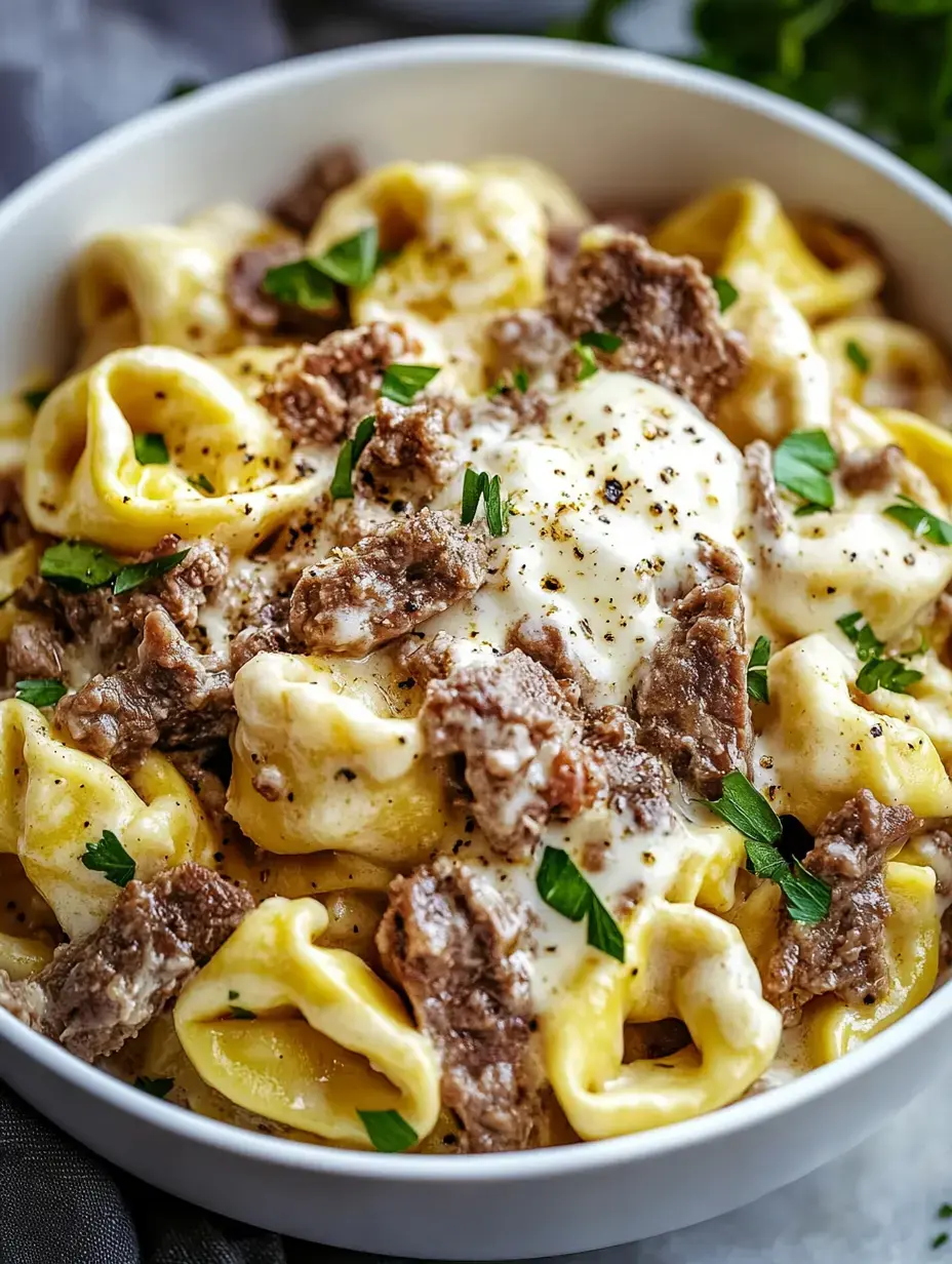 Un tazón de pasta cremosa con trocitos de carne y perejil encima.