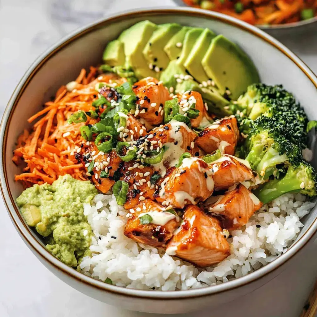Tazón con arroz sushi, pescado dorado, aguacate, brócoli, zanahoria y una salsa cremosa.